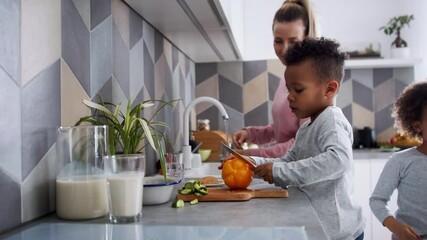 Wall Mural - Multi ethnic family with two small children preparing food at home.