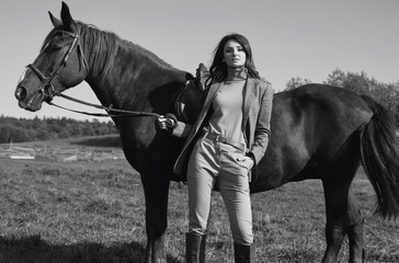 beautiful brunette woman in an elegant checkered jacket with a horse