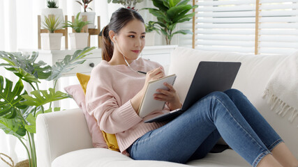 cozy relax young attractive asian female employee wear earphone listen to digital online course deve