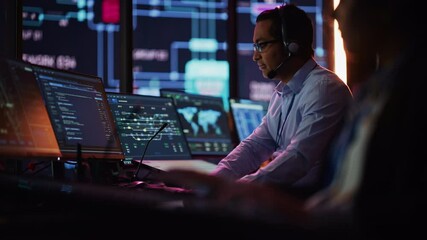 Aufkleber - Professional IT Technical Support Specialist and Software Developer Working on Computer in Monitoring Control Room with Digital Screens. Employee Puts on Headphones with Mic and Talking on a Call.