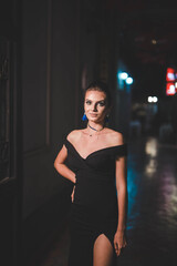 Sticker - Attractive young female in an elegant black dress posing in the street at night