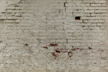 Old faded dirty wet shabby brick wall of ancient ragged facade. Uneven pitted fissured stone. Rusted rot, messy cracked stiff blocks. Retro white grimy rusty daub brickwall for 3D rustic grunge design