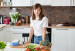 © mdyn - Unhappy Brunette Woman in white t-shirt preparing food in the kitchen at home, Wife Cutting ingredients on table. Healthy Food, Vegan Salad. Dieting Concept.