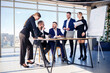 © Дмитрий Ткачук - Business people working together in a modern office with cityscape view. The director tells the staff about new technologies. Office work concept