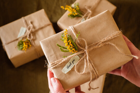 female hands holding gift boxes decorated with yellow flowers a thank you. Appreciate Concept. top view.