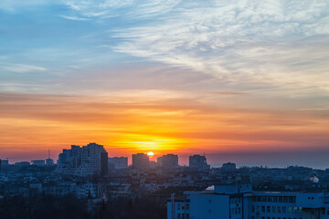 Wall Mural - sunrise over a small town. the rising sun turned the sky golden orange. dawn fire in the sky over a 