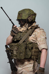 Russian military police soldier in desert uniform. Patch on the shoulder flag of Russia, arms of Russian army and the inscription Military Police in Russian. Shot in studio on a grey background.