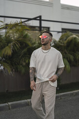 Canvas Print - Vertical shot of a tattooed stylish man walking on the street