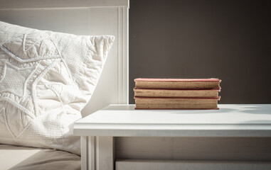 Canvas Print - books on retro white table by bed    Scandinavian interior  neutral color palette.