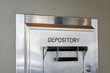 © MichaelVi - Depository sign on an exterior secured bank drop box attached to the wall of a bank building.