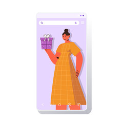 woman celebrating online birthday party girl in smartphone screen holding gift box