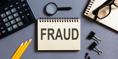 Poster - Notepad with inscriptions FRAUD on a grey background with office tools . business concept.