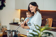 Mother with child stirring with ladle in saucepan