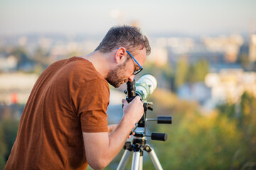 Wall Mural - amateur astronomer looking at the sky with a telescope.