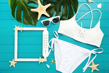 Wall Mural - Fashion swimsuit with starfishes, sunglasses and monstera leafs on blue wooden table