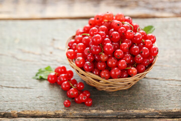 Canvas Print - Sweet red currants in basket on wooden background