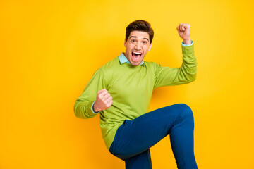 Poster - Photo of young happy crazy ecstatic smiling cheerful good moo man raise fists in victory isolated on yellow color background