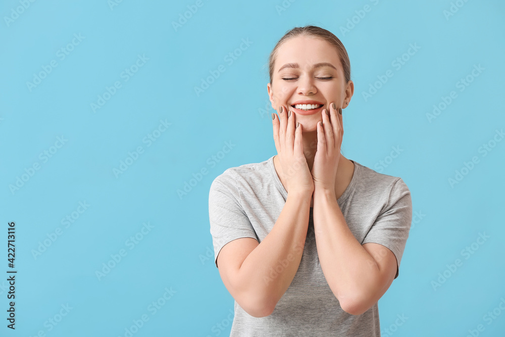 Beautiful smiling young woman on color background