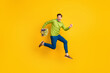 © deagreez - Full length body size profile side view of nice cheery crazy guy jumping running carrying flowers floristry isolated on vivid yellow color background