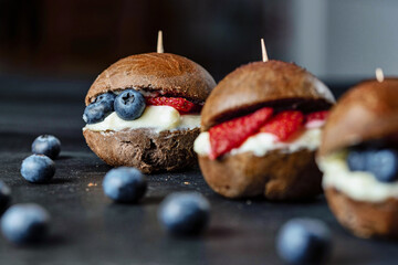 Original recipe. Choco burger with strawberries and blueberries. Small sweet burgers.