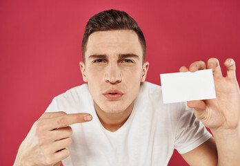 The guy in a white T-shirt with a rosette in his hand on a red background advertising model