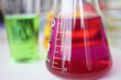 Glass flasks with colored liquids standing on table in chemical laboratory closeup