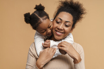 Happy black mother and daughter hugging while making fun together