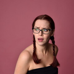 Wall Mural - close up portrait of red haired women with different facial expressions on a pink studio background.