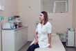 © Nona Liuter - The cosmetologist is preparing to receive clients. A beautician in a white coat is standing in his beauty parlor. Doctor beautician in a white medical coat, against the background of the office.