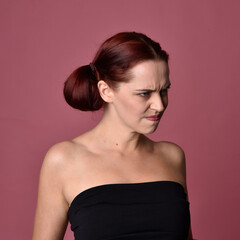 Poster - close up portrait of red haired women with different facial expressions on a pink studio background.