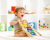 Fototapeta  - Little child boy playing with toy blocks. Baby in nursery or kindergarten