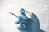 Fototapeta Dmuchawce - hand in latex gloves holding glass ampoule vaccine, with copy space 