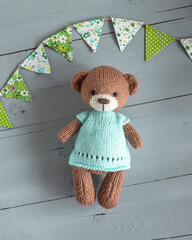 Wall Mural - A stuffed teddy bear in a mint dress.