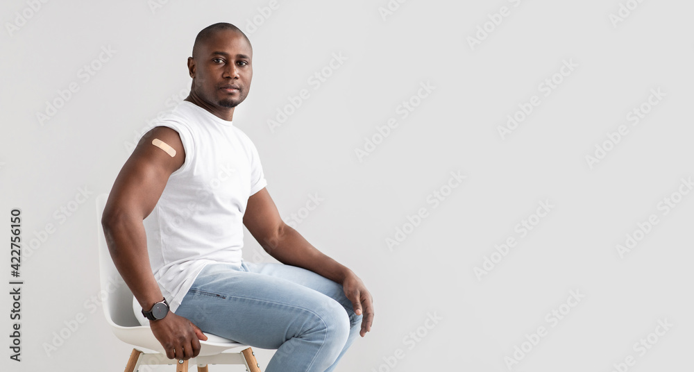 Positive black man with plaster on shoulder after injection of covid-19 vaccine, panorama with free space - obrazy, fototapety, plakaty 