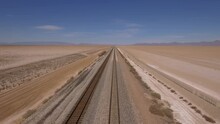 Aerial Of Train Tracks Leading Off Into The Distance On A Desert Dry Lake