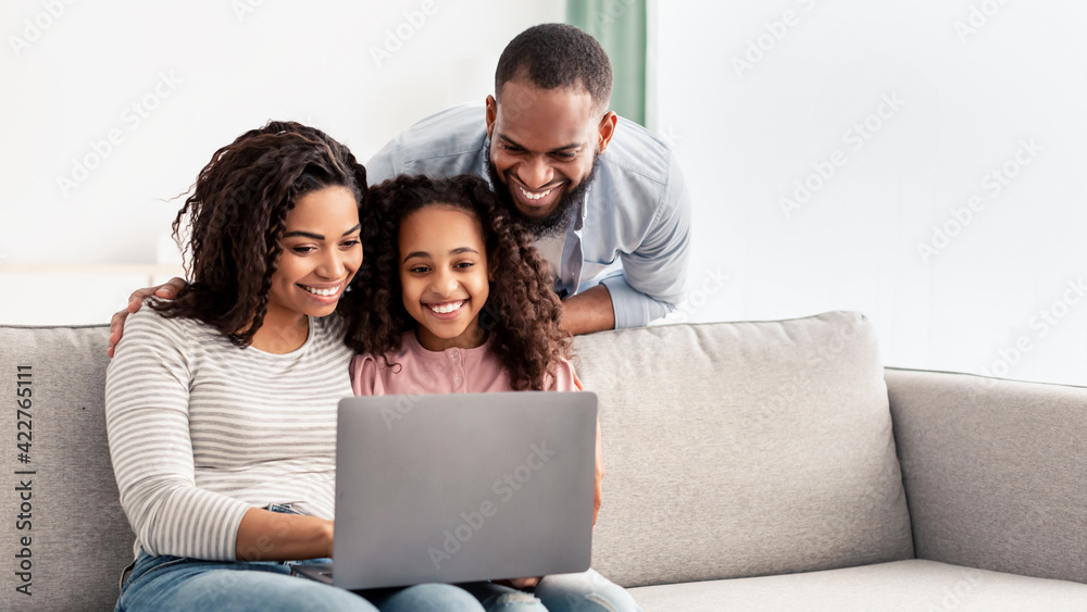 Happy african american family using laptop in living room Stock Photo ...