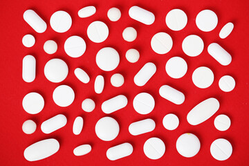 Wall Mural - Bright red background with white medicine tablets