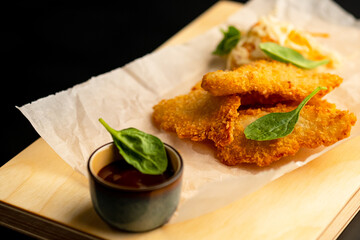 Chicken fillet breaded with sauce. Harmful food.