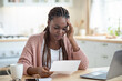 © Prostock-studio - African American Female Freelancer Having Stress While Working With Papers At Home