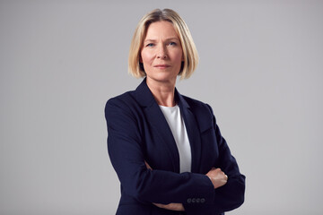 studio portrait of serious mature businesswoman against plain background