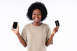Cheerful african girl holding smart phone and credit card isolated in white