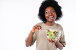 Cute african-american teen girl eating salad isolated over white background