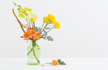 Roses And Orchids In Green Glass Vase On White Background