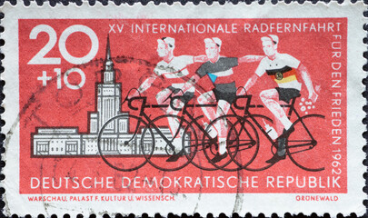 Wall Mural - Cyclists with the national team jerseys in front of the Palace of Culture in Warsaw. International Long Distance Cycling for Peace Berlin-Prague-Warsaw