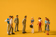 © KseniaJoyg - Miniature people on a yellow background, men against women at work. The concept of gender equality, feminism