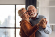 © Goran - Happy mature couple having fun while dancing at home
