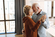 © Goran - Happy mature couple having fun while dancing at home