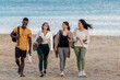 © Juan Algar - Cheerful diverse friends walking on beach together
