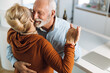 © Goran - Happy mature couple having fun while dancing at home