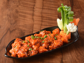 Wall Mural - Assorted indian food Chicken manchurian on wooden background. Dishes and appetizers of indian cuisine, selective focus